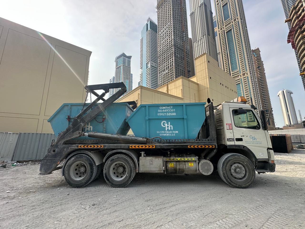 GPh skip loader truck delivering a skip on a Dubai construction site